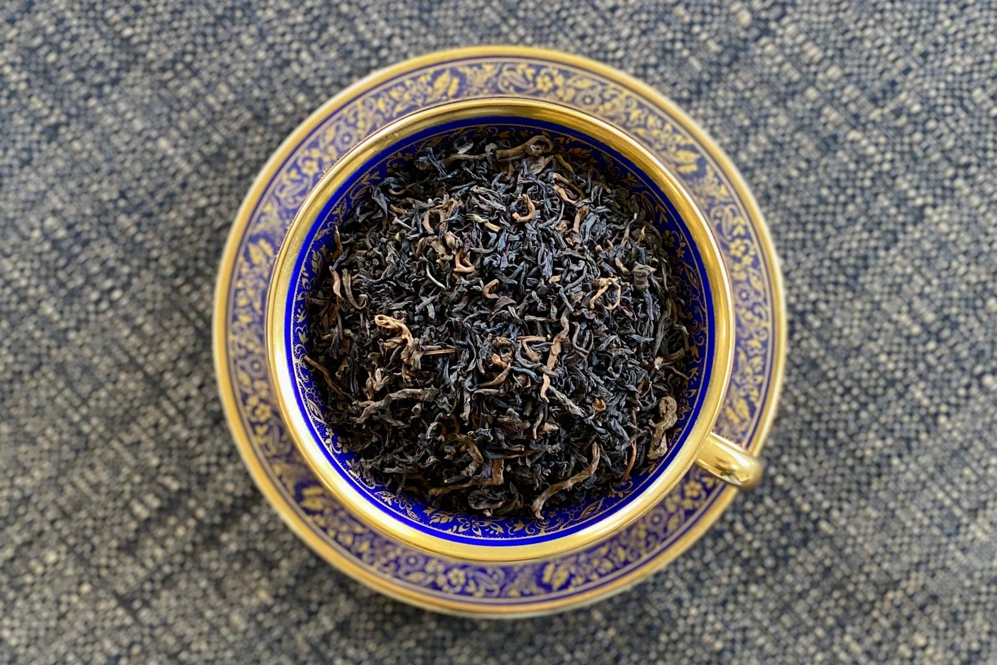 Teacup full of dark tea leaves