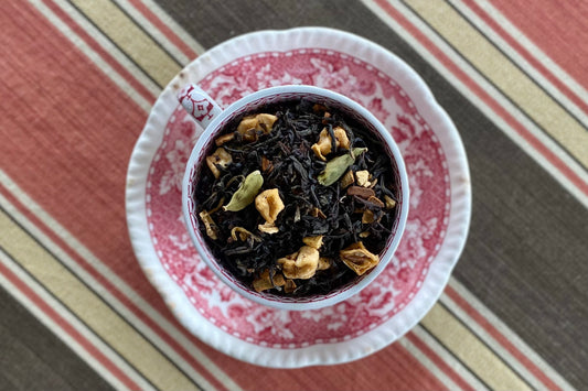 Teacup full of black tea, spices and apple pieces