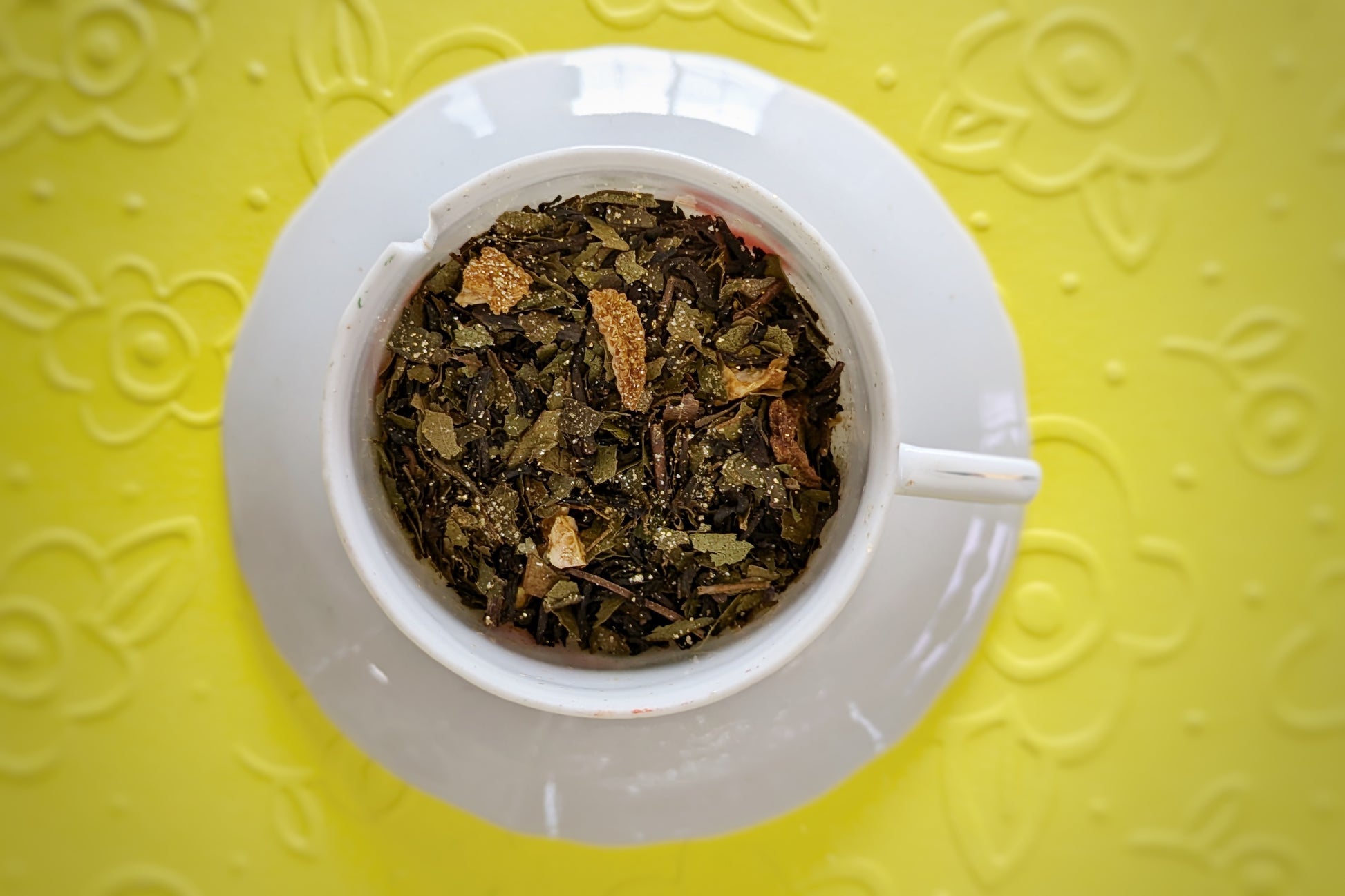 teacup with herbs, black tea, and lemon peel