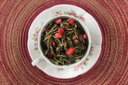 teacup full of white tea and strawberry pieces